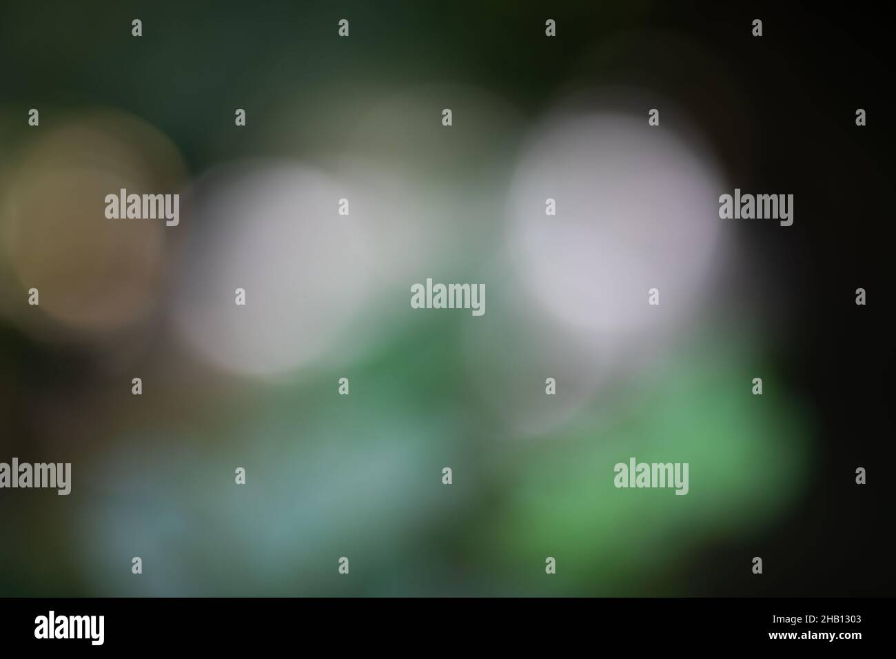 background bokeh blurred light reflections in green, white, black and yellow Stock Photo