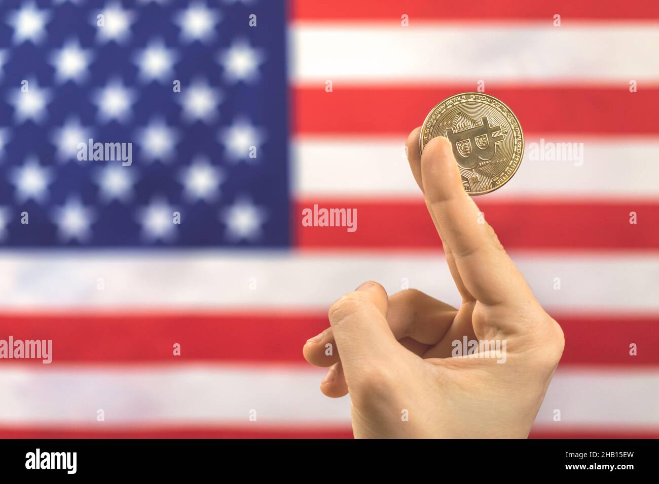 Man holds bitcoin against American flag background photo Stock Photo