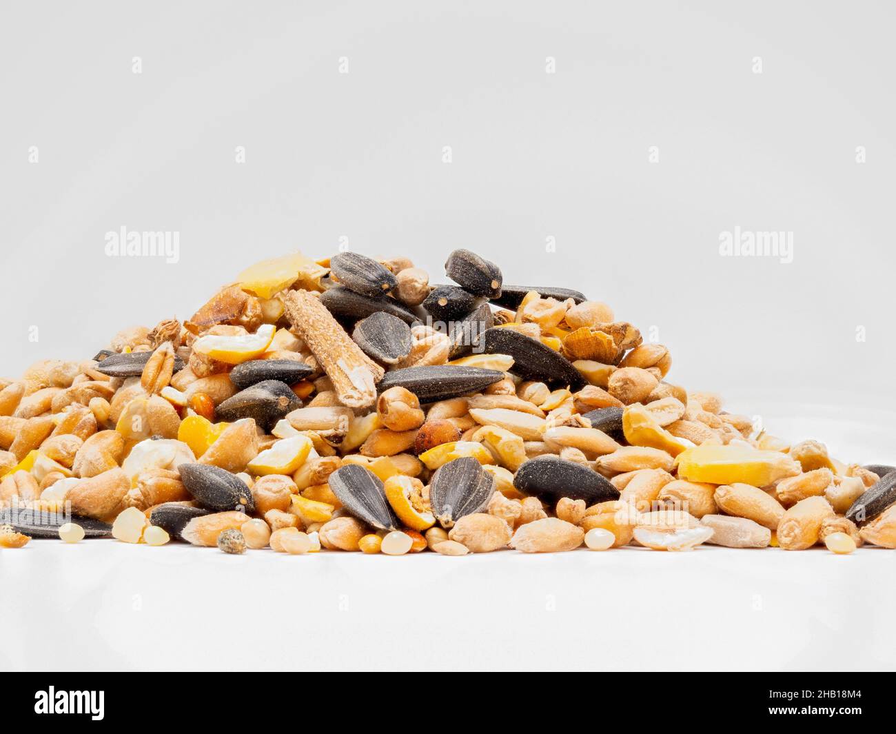Natural winter food selection of natural seeds, nuts and pulses to refill feeders for wild birds Stock Photo