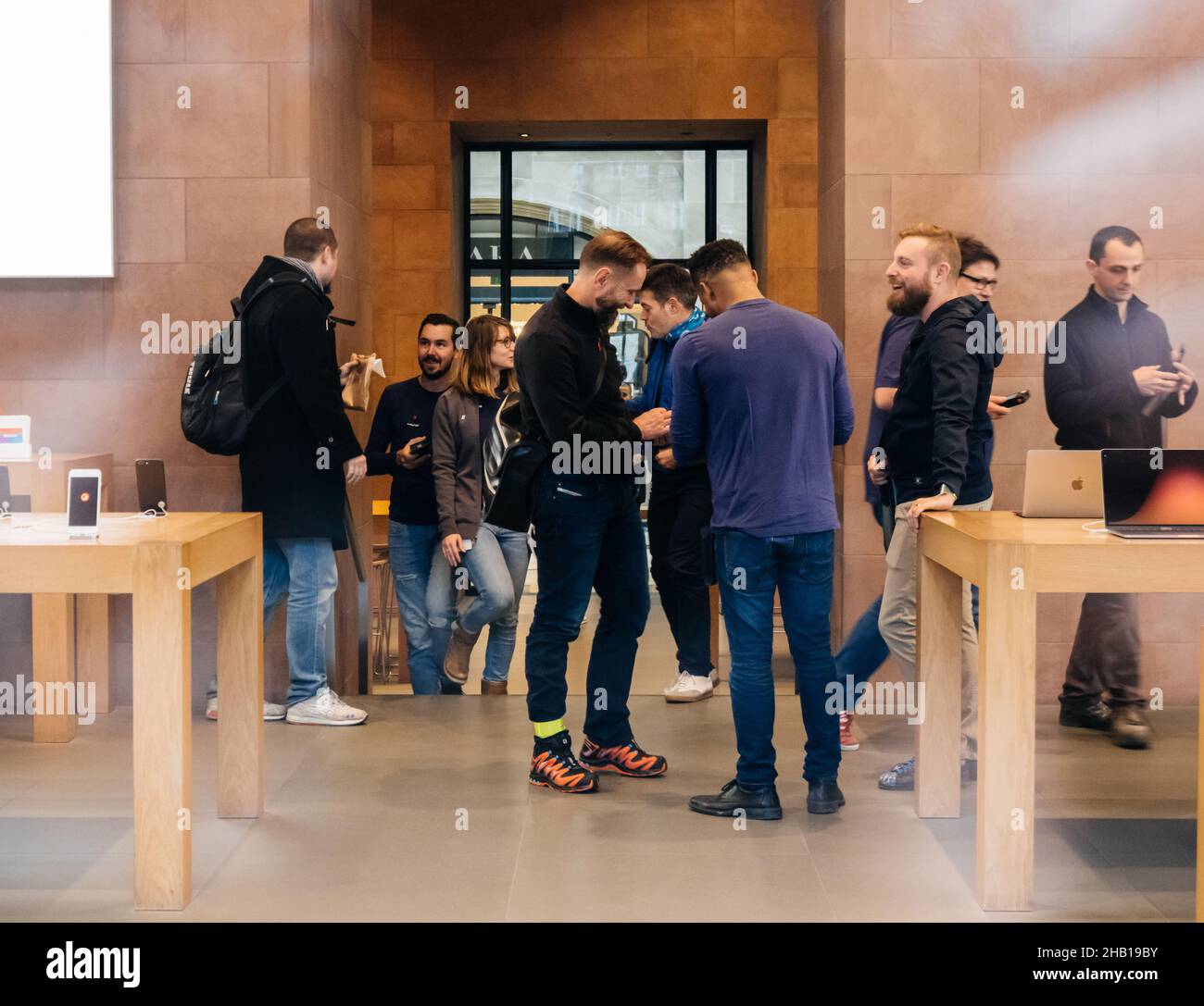 Crowd of people waiting in queue at the entrance of Apple Store during ...
