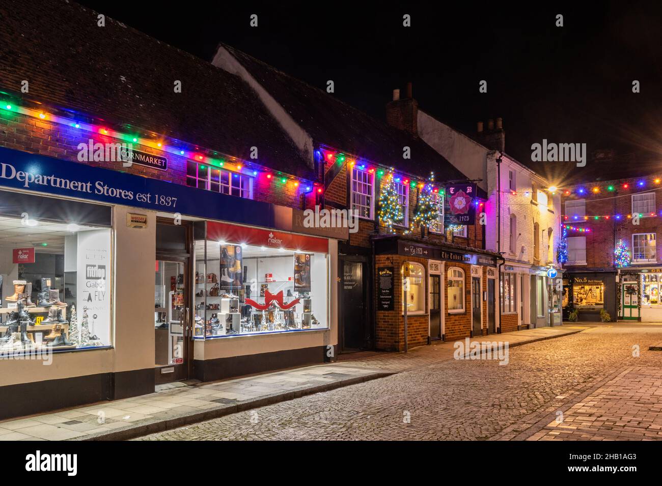 December 15th, 2021. Romsey town centre in Hampshire, UK, has been decorated and lit up with colourful Christmas lights. The Corn Market, shops and Tudor Rose pub. Stock Photo