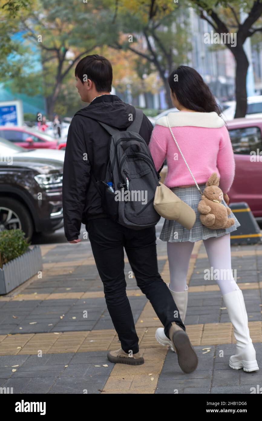 Back view of a young couple walking on the street of Beijing Stock ...