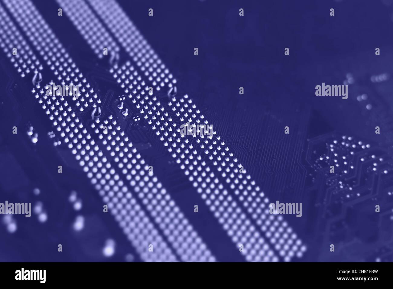 Defocused trendy very peri color concept of the year 2022, violet blue, lavender computer motherboard closeup background. Selective focus Stock Photo
