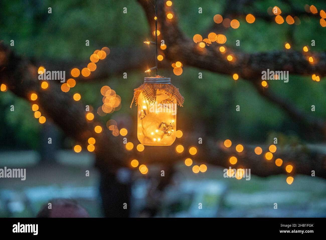 Mason jars filled with warm glowing lights decorations hanging from