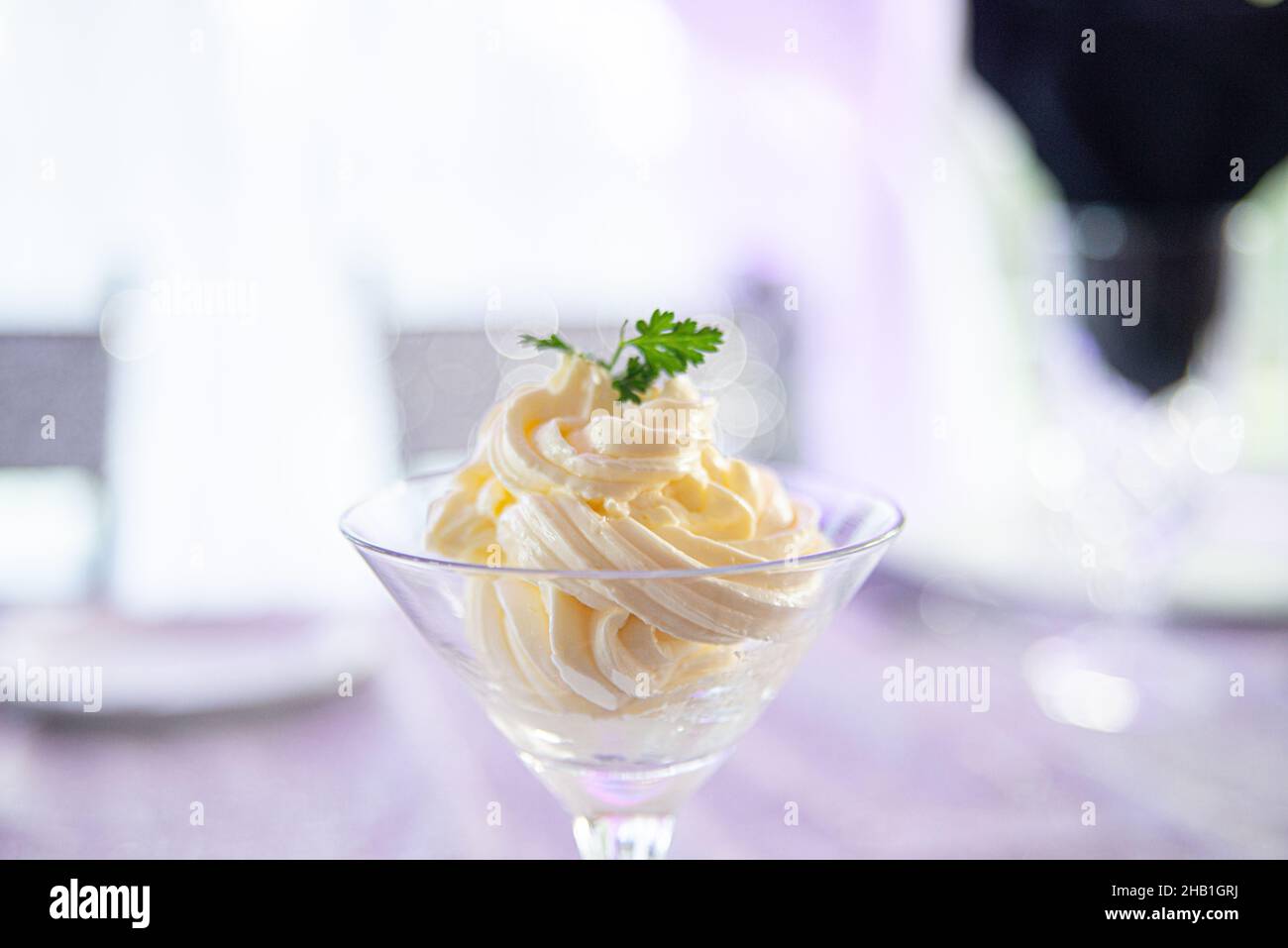 Martini glass filled with whipped butter and basil at elegant dinner