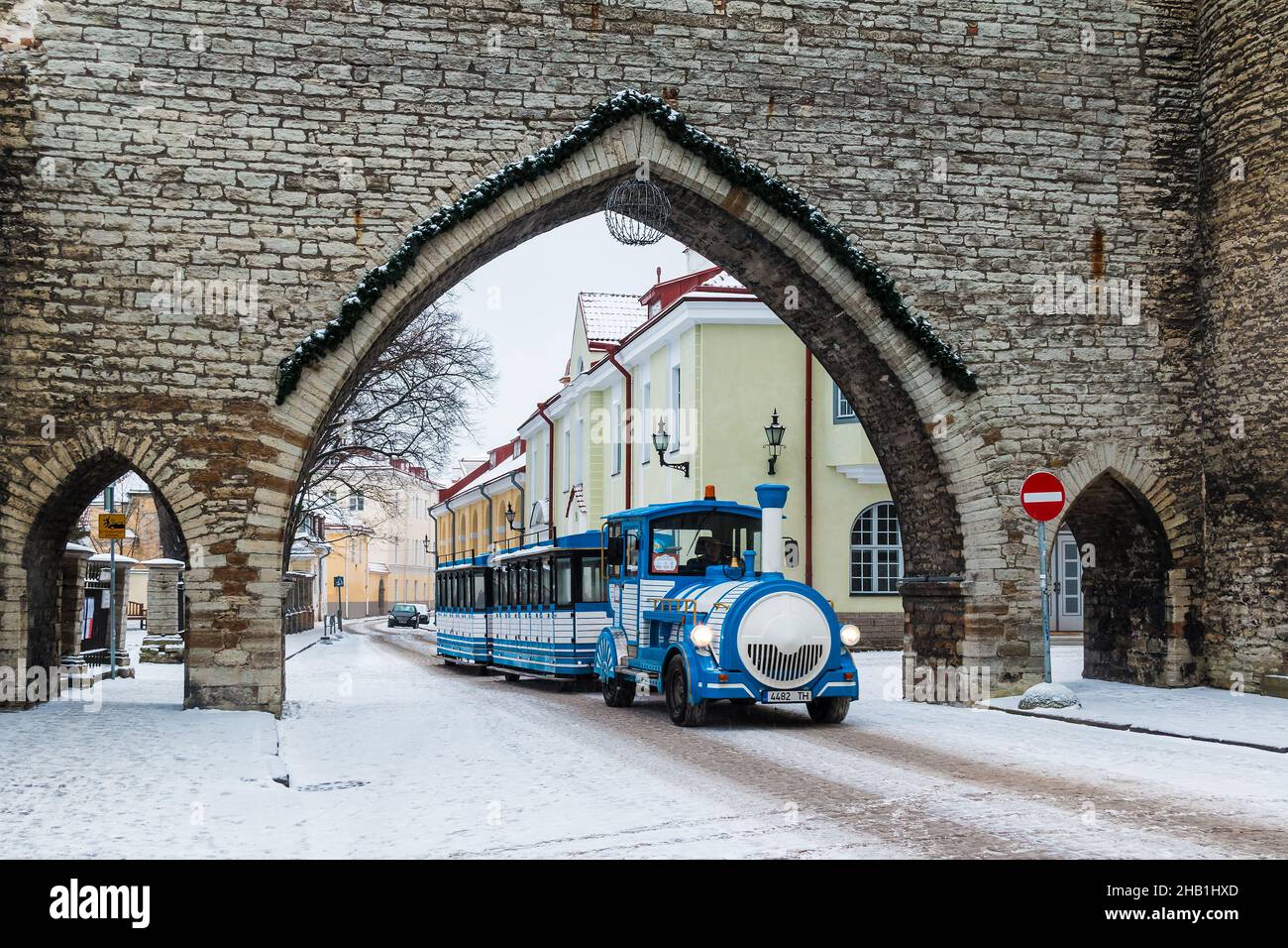 Tallinn, Estonia - December 25, 2018: The city train passing through the Monastery Gate and perspective view of the Suur-Kloostri Street in the Tallin Stock Photo