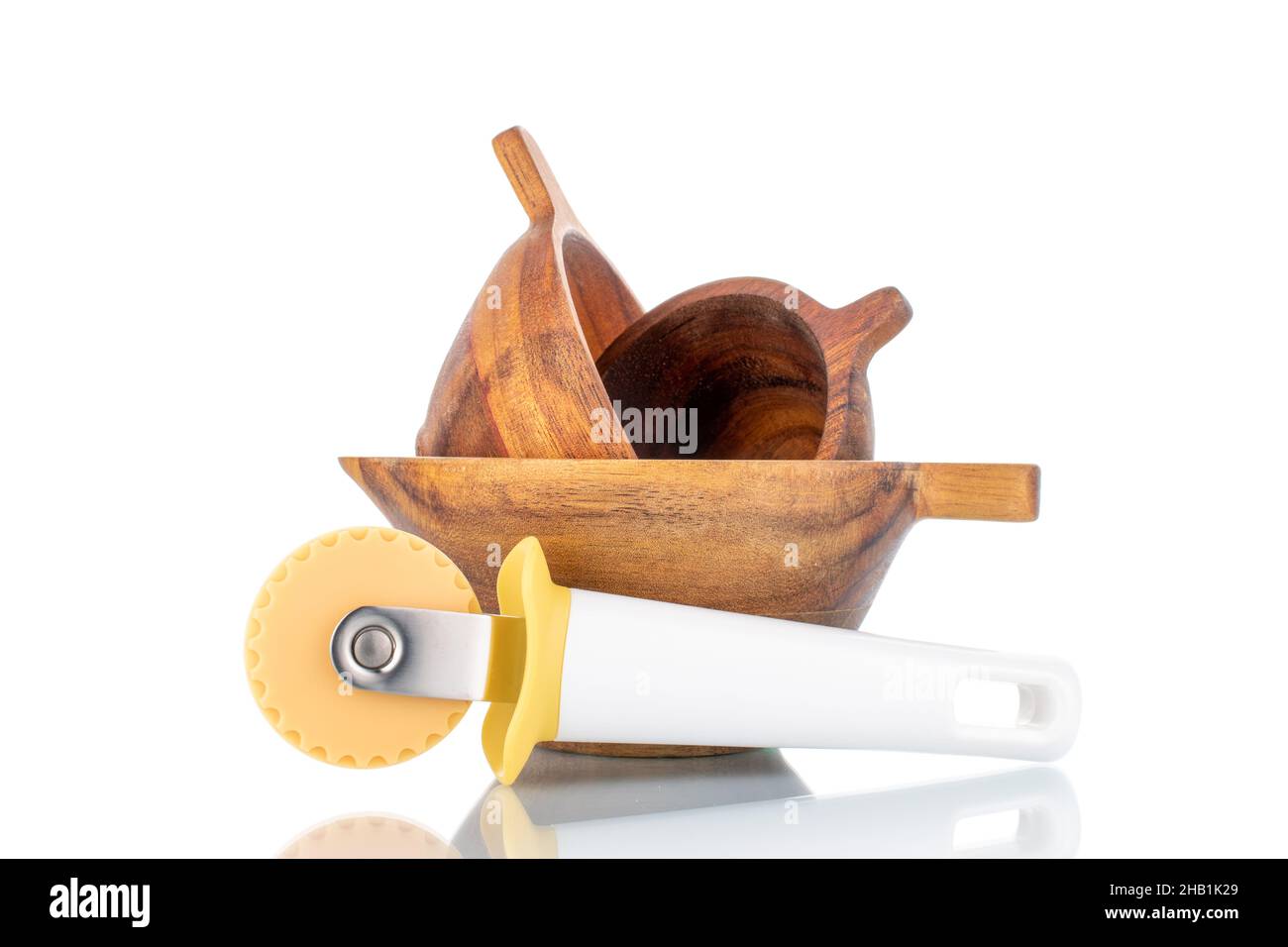 One plastic dough knife and three wooden cups, closeup, isolated on