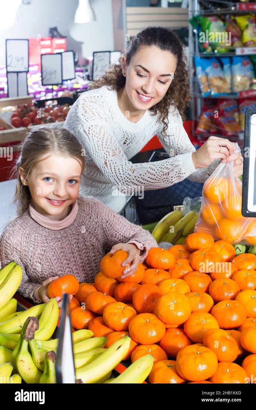 Mother and child purchasing mandarins in market Stock Photo Alamy