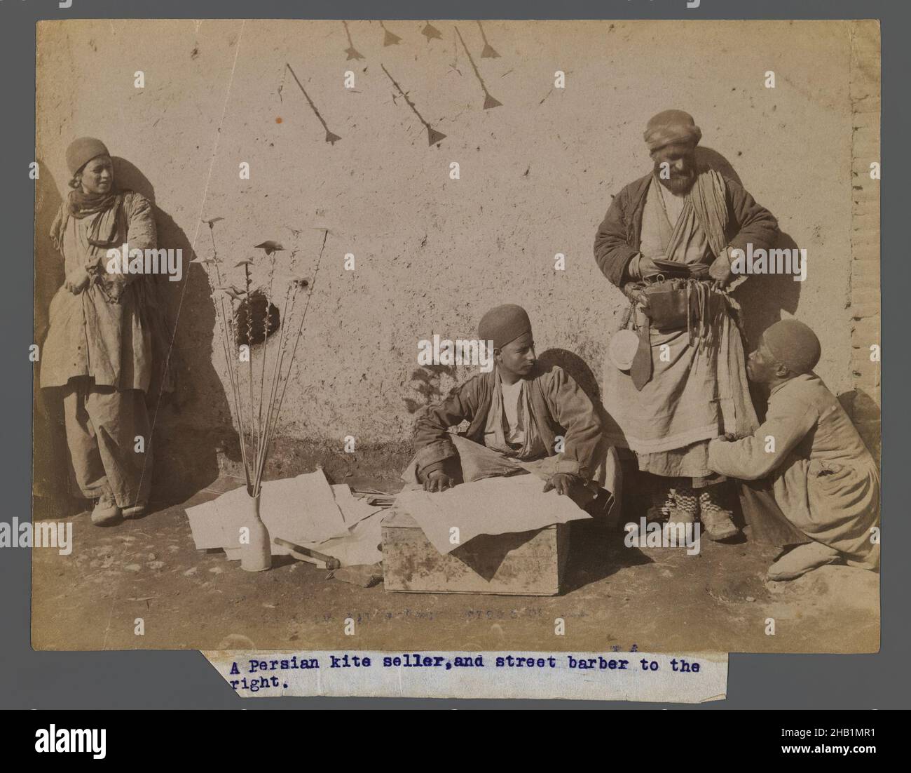 A Persian Kite Seller and Street Barber, One of 274 Vintage Photographs, Albumen silver photograph, late 19th-early 20th century, Qajar, Qajar Period, 6 1/8 x 8 3/16 in., 15.5 x 20.8 cm, commerce, craft, hobby, kite, leisure, pastime, recreation, sport, vendor Stock Photo