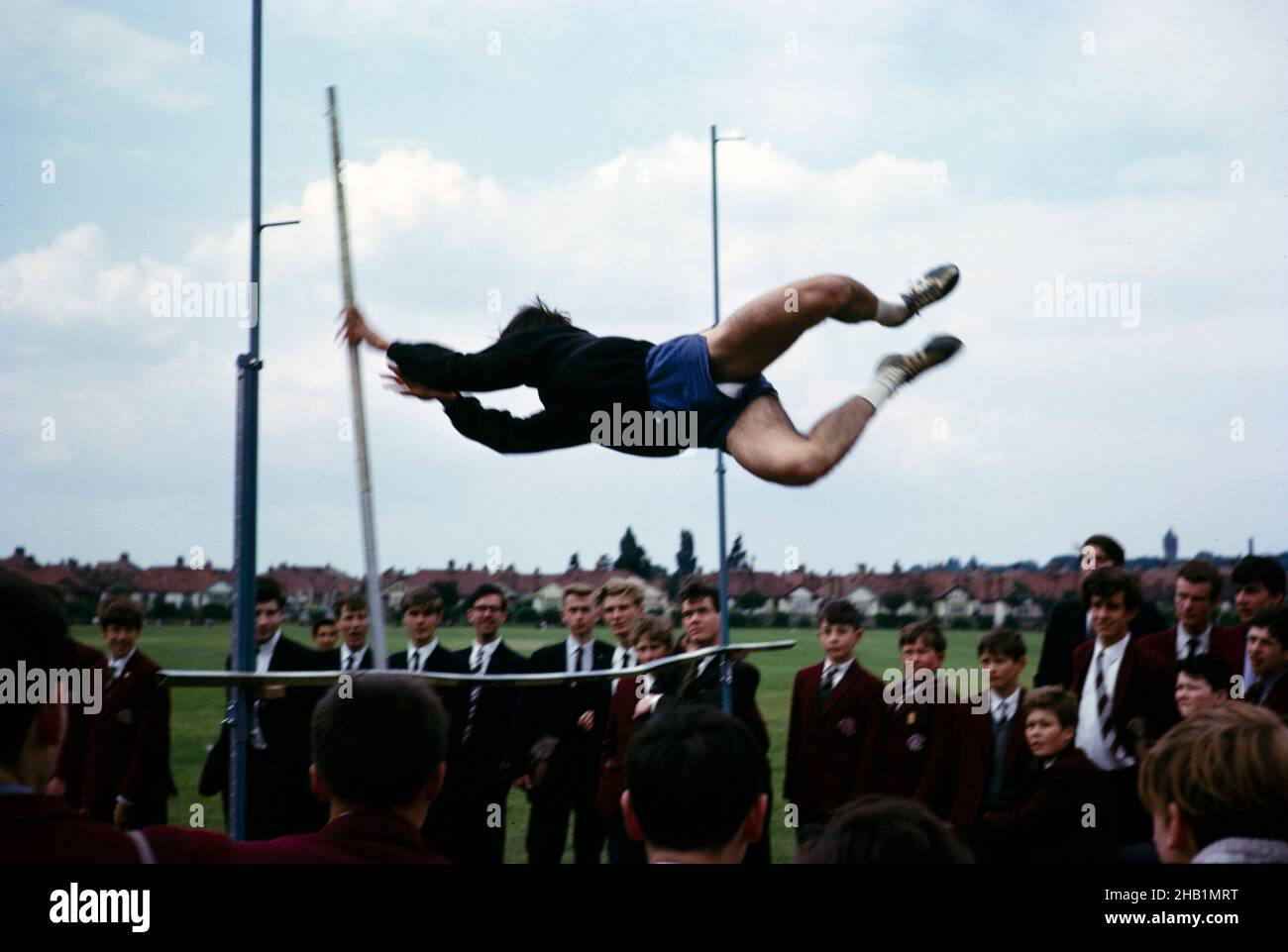 Boy competing in pole vault event at secondary school sports day