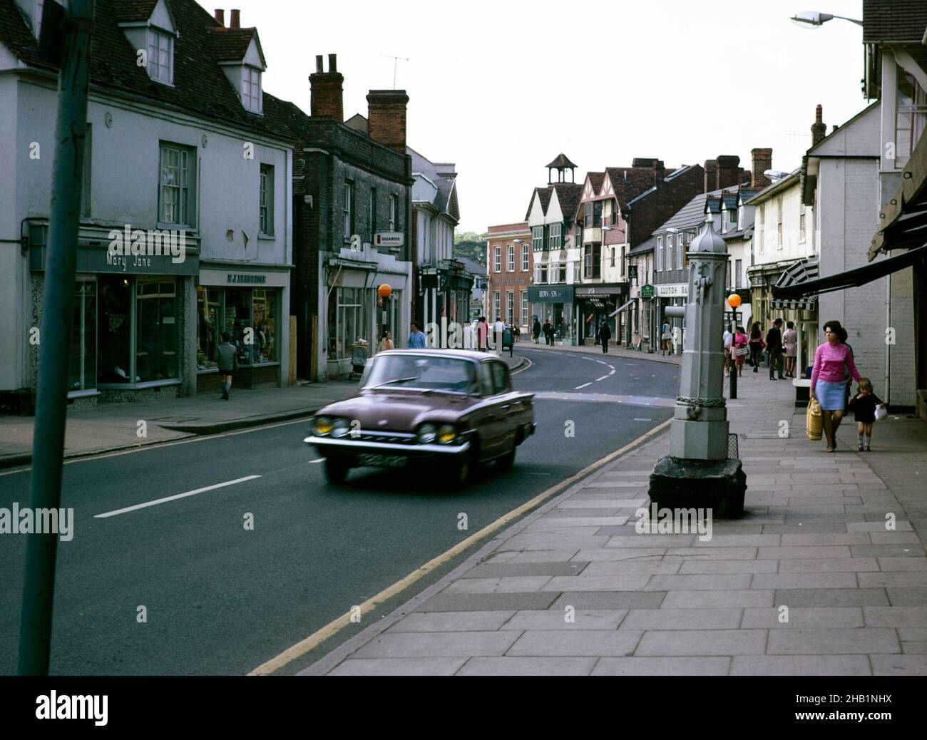 Vintage water pump on High Street, Great Dunmow, Essex 1970 with Ford Consul Classic car Stock Photo