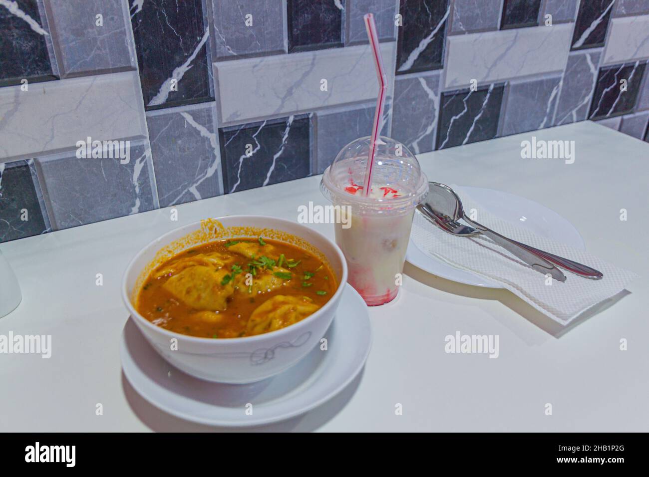 Dumpling soup with a milk drink in an eatery in Dubai, UAE Stock Photo