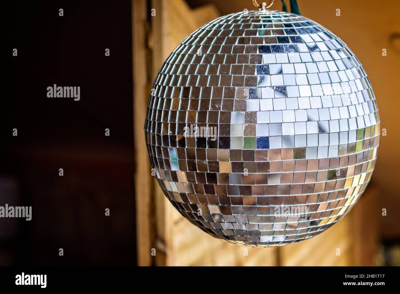 Close up of a silver reflective disco hanging outside Stock Photo - Alamy