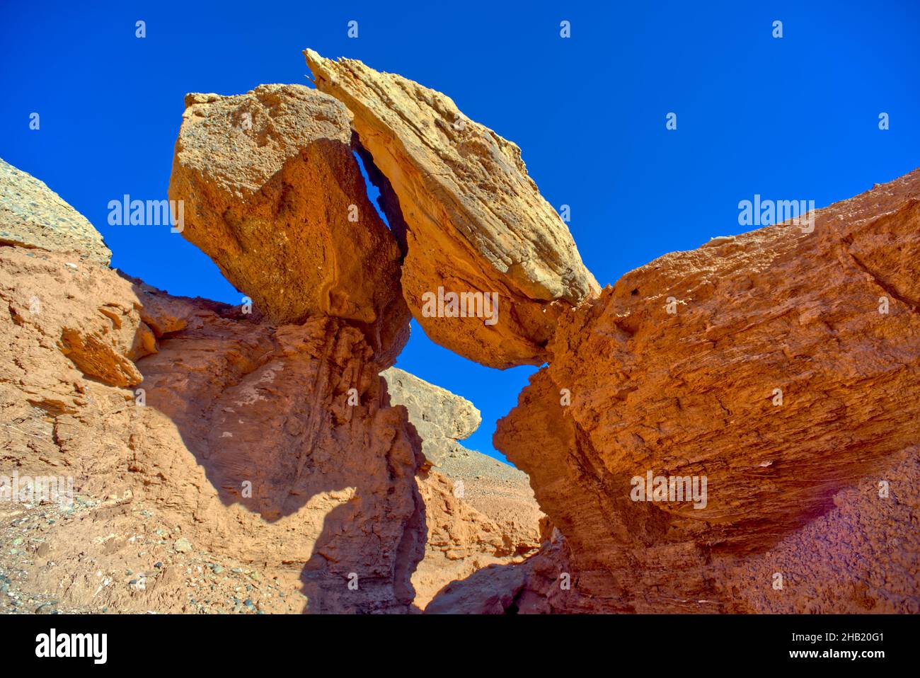 Pair of balanced boulders over a narrow slot in Chocolate Canyon in Vermilion Cliffs National Monument at Glen Canyon Recreation Area Arizona. Stock Photo