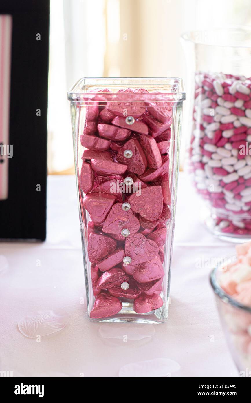 Heart shaped chocolate candies wrapped in pink aluminum foil at dessert bar Stock Photo