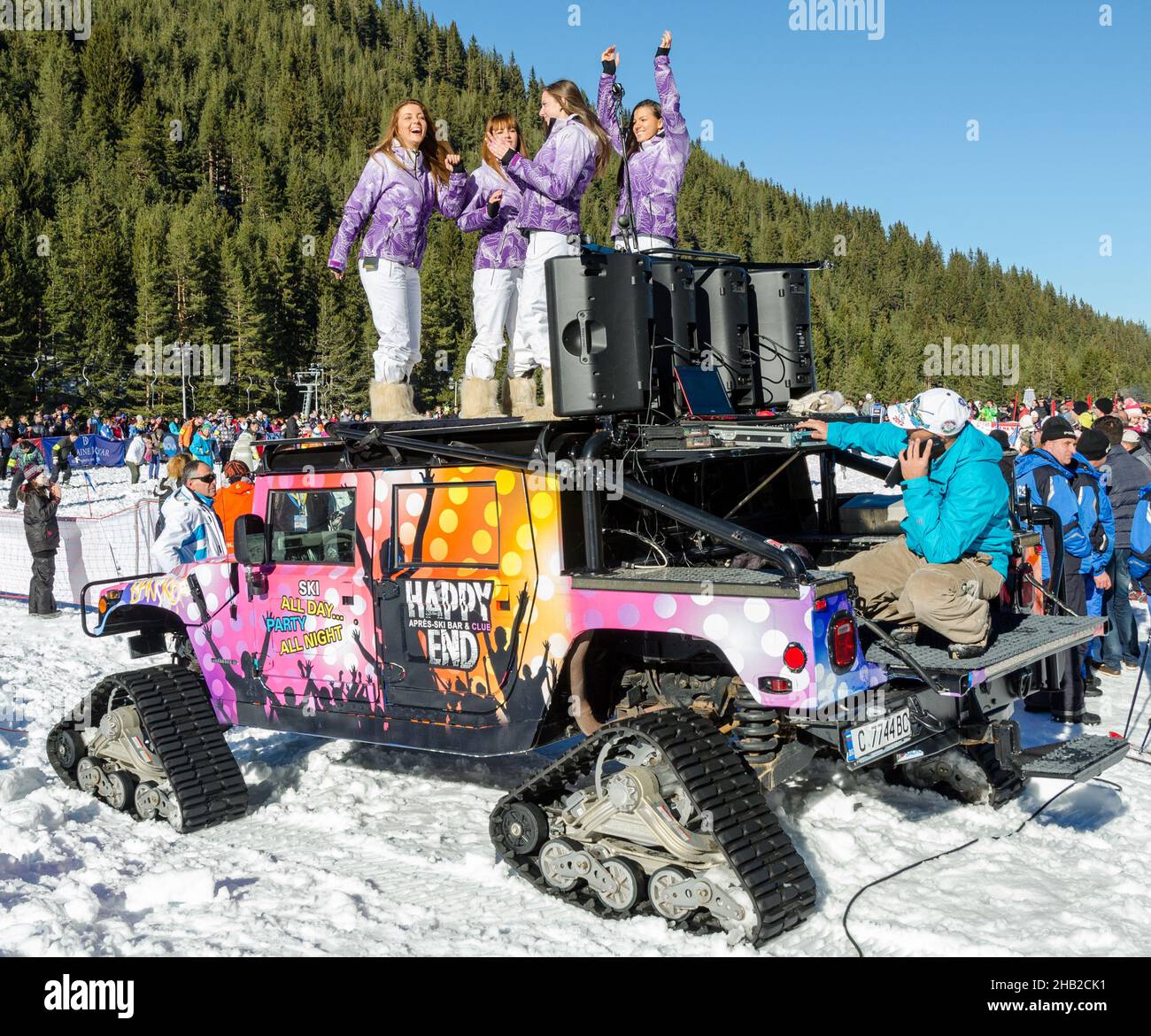 Girls dance on a GMC Hummer with chains at the opening of the ski season in Bansko, Bulgaria. Stock Photo