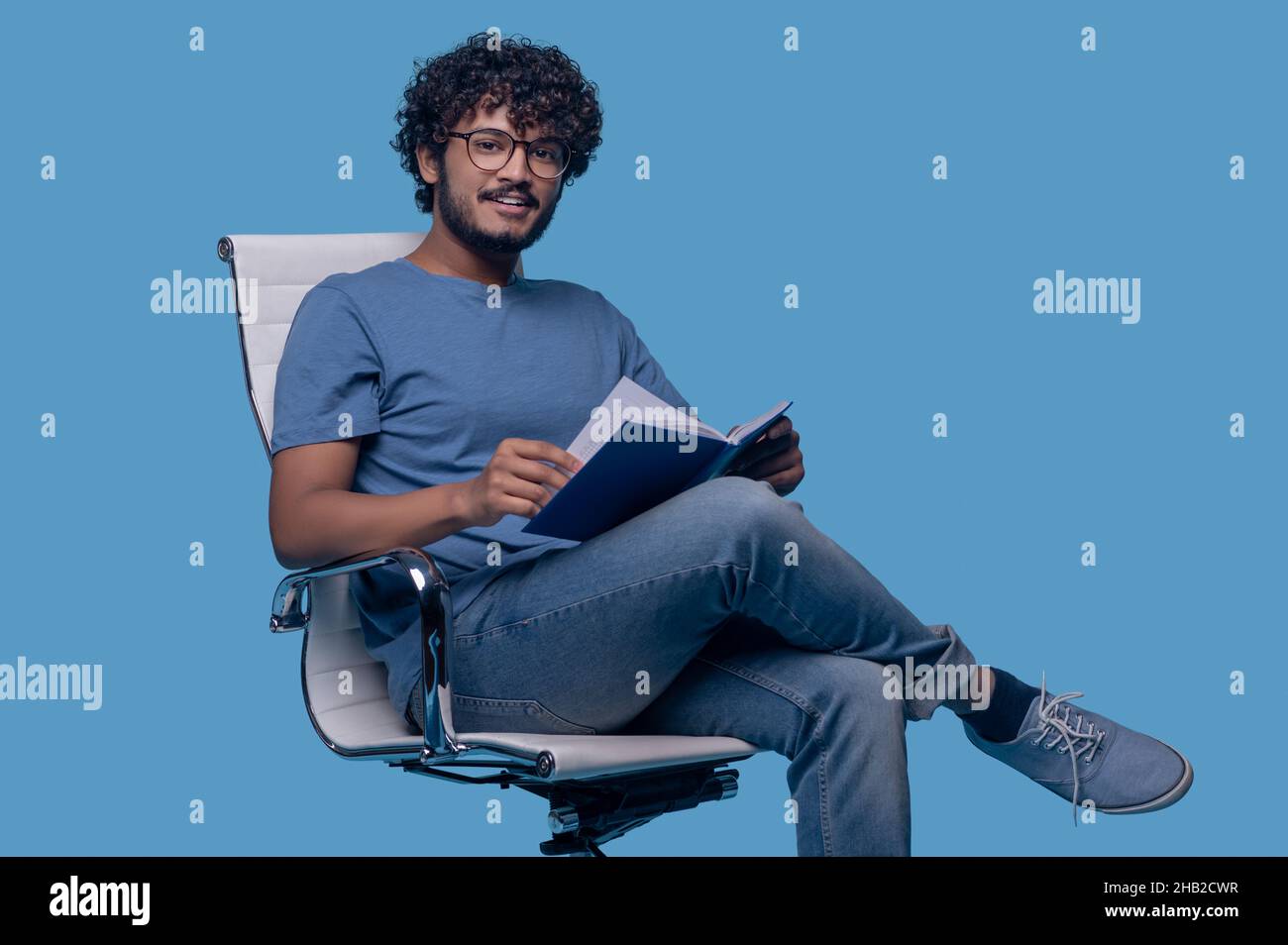 Pleased cute guy with a diary looking ahead Stock Photo