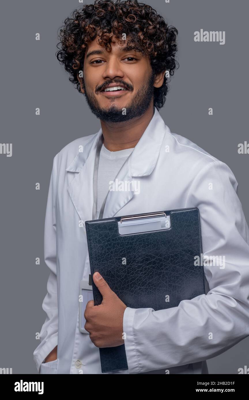 Cheerful doctor with documents looking in front of him Stock Photo