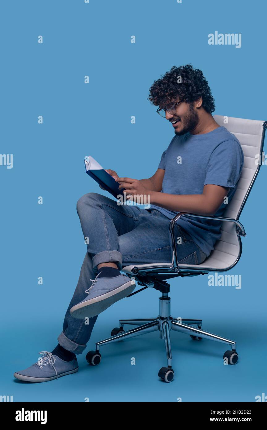 Smiling guy focused on reading his notes Stock Photo