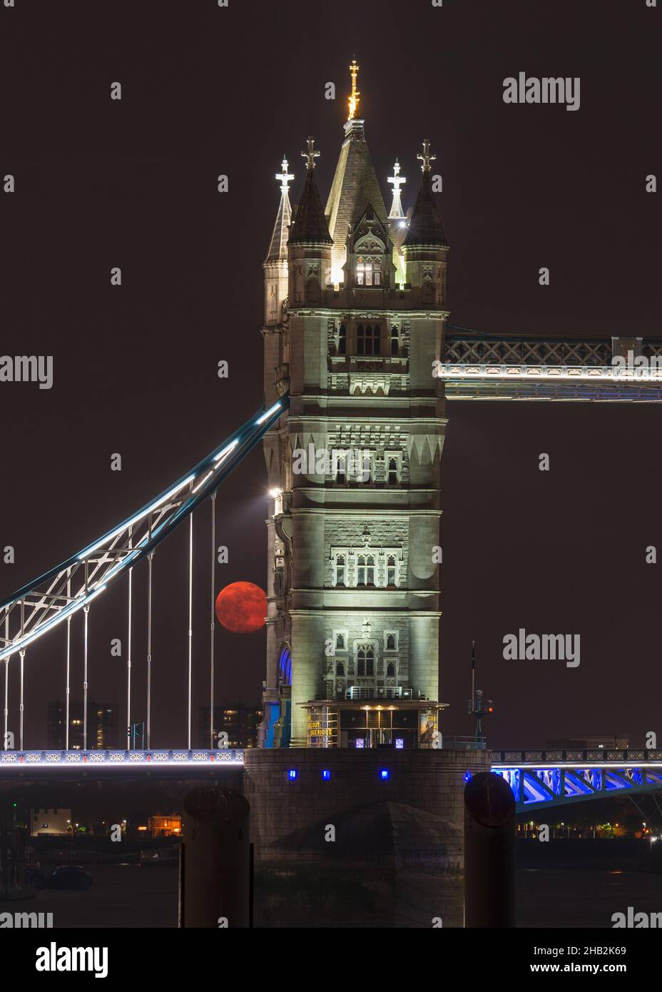 a night time view of a full moon rising behind the illuminated Tower ...