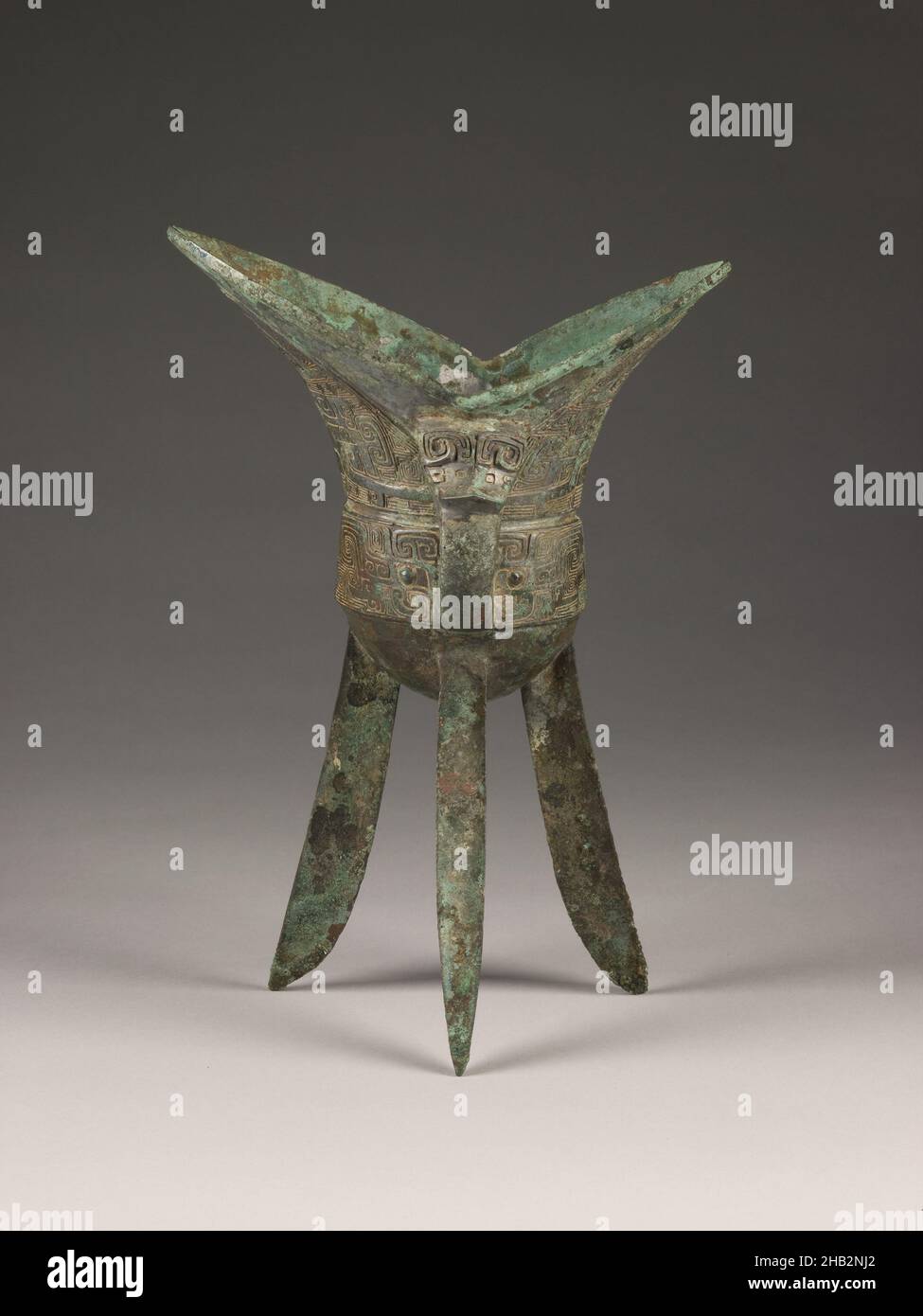 Tripod Wine Vessel (jiao) with Design of Zoomorphic Masks and Spiral Patterns, Chinese, Shang dynasty, 1600–1050 BC, 13th century BC, Bronze, China, Asia, Containers, metalwork, height: 9 1/2 in. (24.1 cm Stock Photo