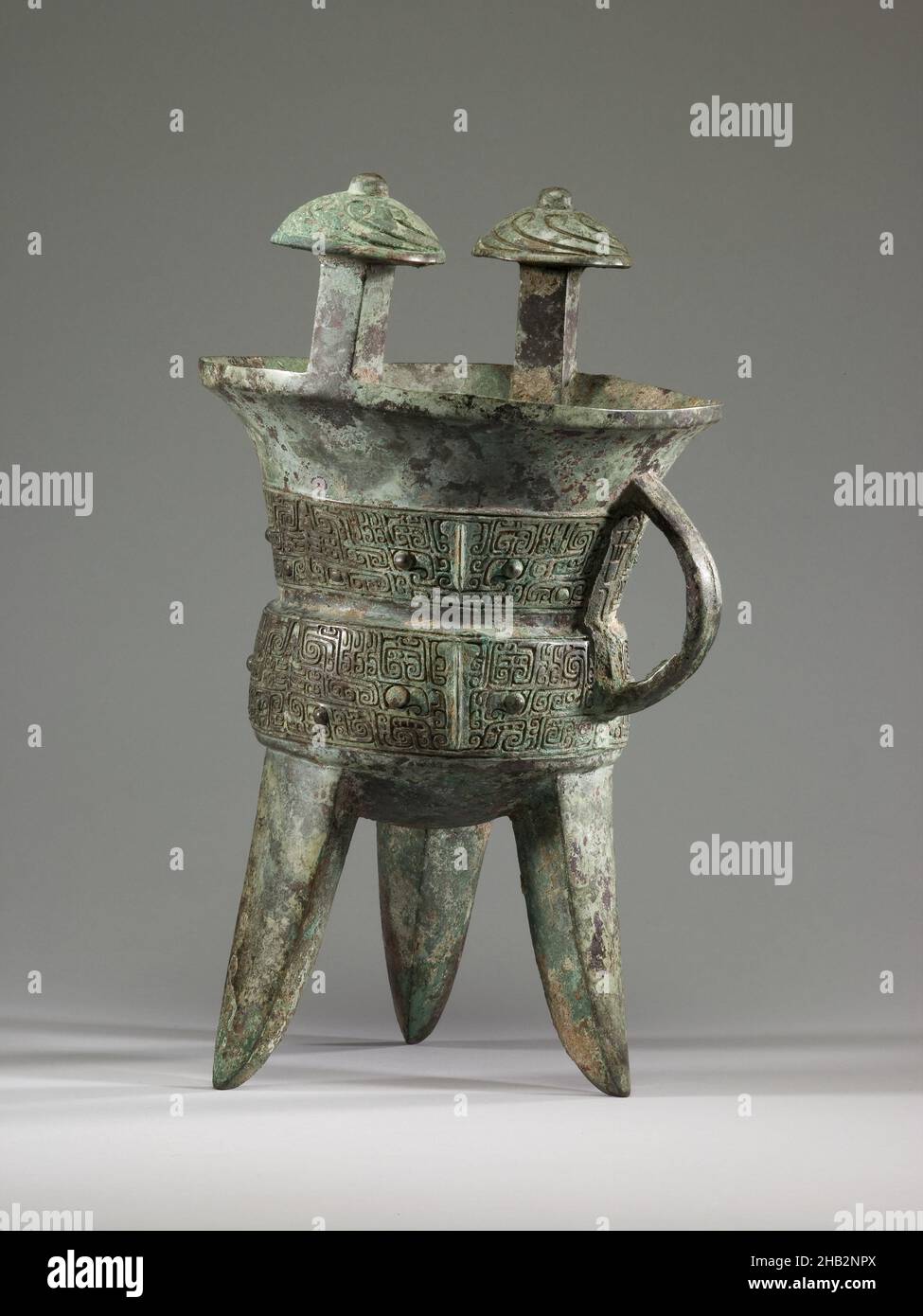 Tripod Wine Vessel (jia) with Design of Zoomorphic Masks, Chinese, Shang dynasty, 1600–1050 BC, 13th century BC, Bronze, China, Asia, Containers, metalwork, height: 13 1/2 in. (34.3 cm Stock Photo
