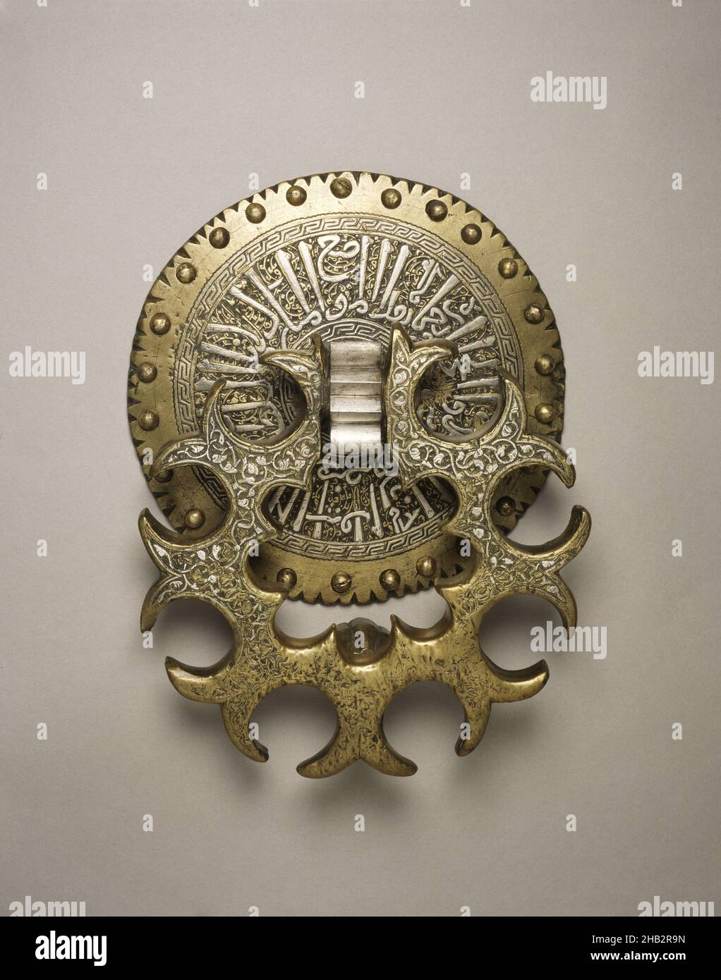 Door Knocker with Eight Lobes and Arabic Inscription on Backplate, Egyptian, Mamluk period, 1250–1517, reign of Qalā'ūn, c.1220–1290; reigned 1279–1290, 1280–90, Brass with silver inlay, Cairo, Northern Africa, Egypt, Africa, Architectural elements, metalwork, height: 8 3/8 in. (21.3 cm Stock Photo
