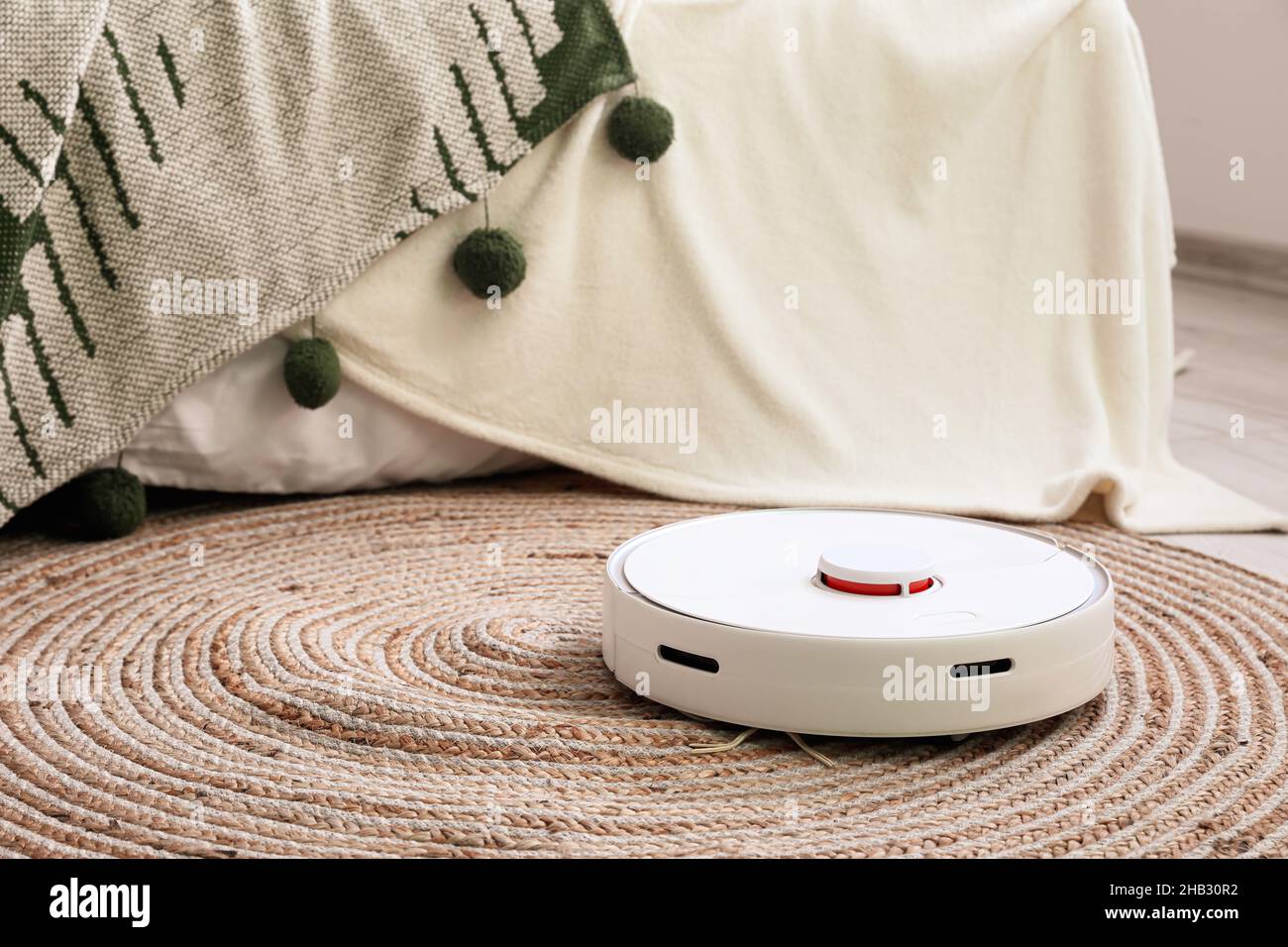 Modern robot vacuum cleaner near bed in room Stock Photo Alamy