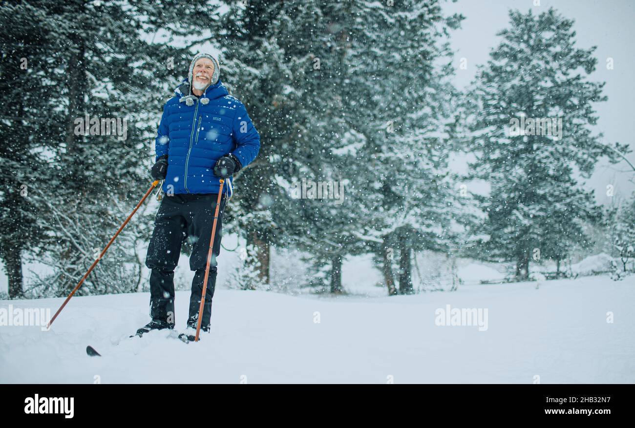 Elderly Man Cross Country Skiing on a snowy day Stock Photo