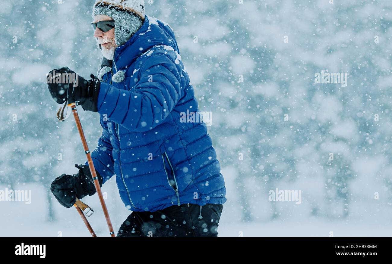 Elderly Man Cross Country Skiing in Snowy conditions Stock Photo