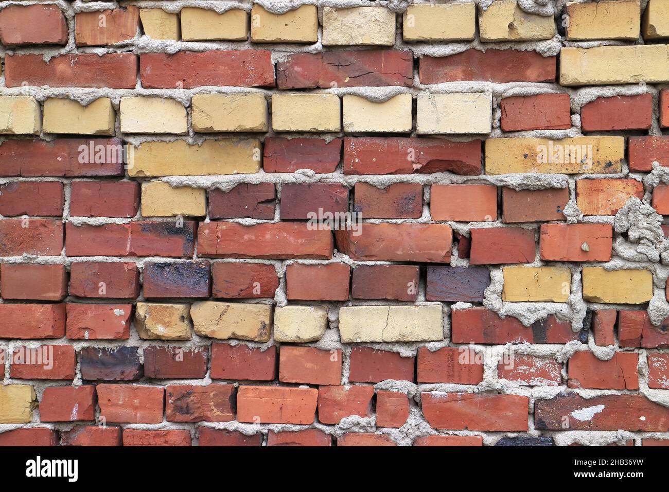 Old brick wall background with various colored bricks Stock Photo