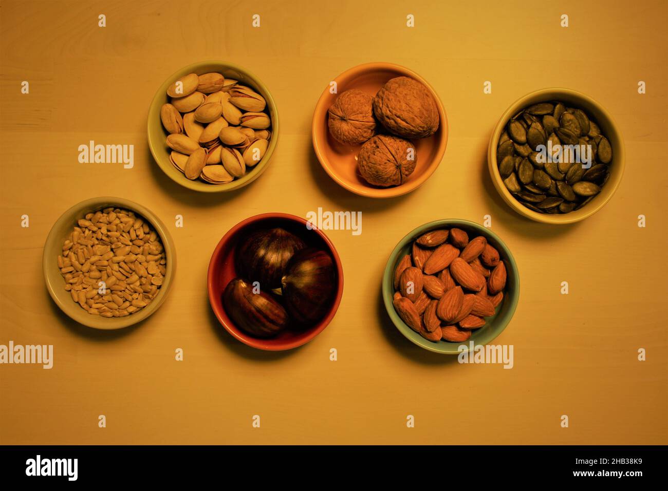 6 ceramic bowls containing whole nuts and seeds. Concept for health