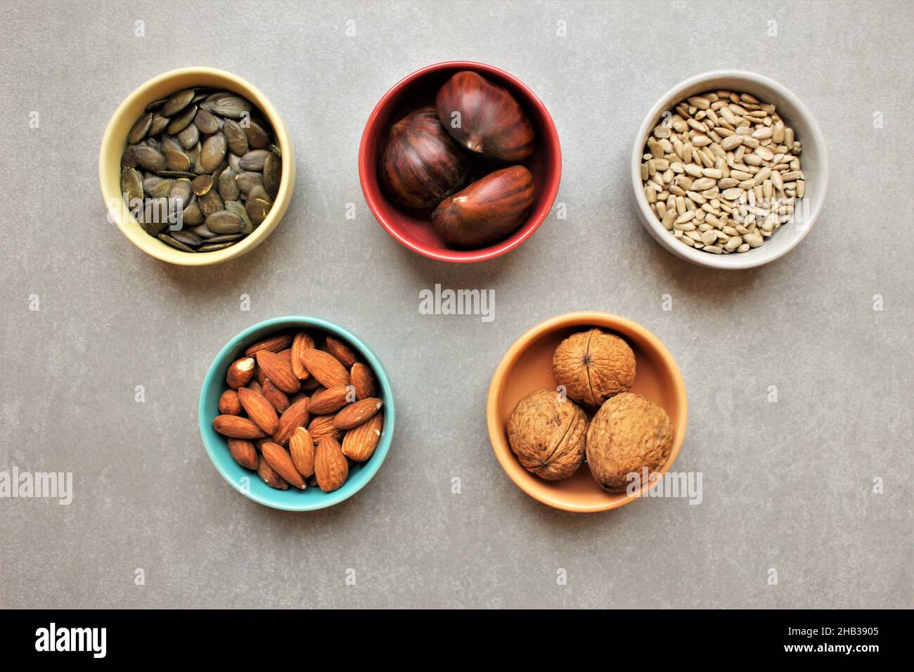 5 ceramic bowls containing whole nuts and seeds. Concept for health foods, whole foods Stock