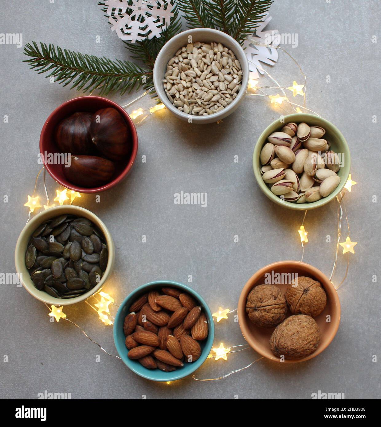 6 ceramic bowls containing whole nuts and seeds. Concept for health