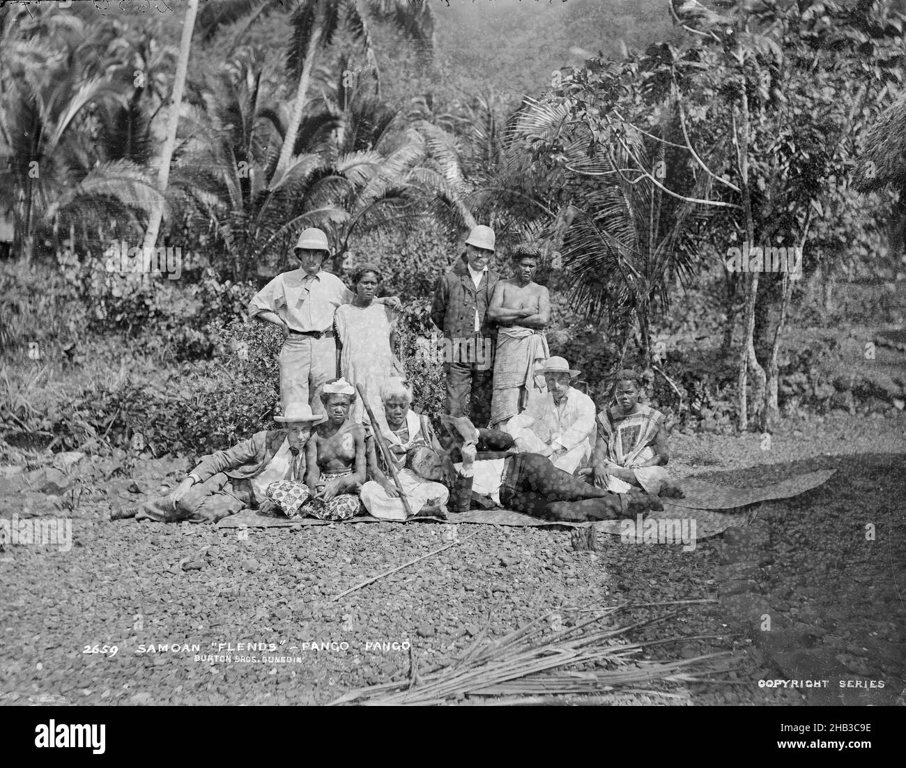Samoan Flends, Pango Pango (sic), Burton Brothers studio, photography studio, 1884, Dunedin, gelatin dry plate process, Informal outdoor group portrait of male passengers from the Wairarapa paired up with local Samoan women. 'Flends' was the name given to Islanders who paired themselves off with a visitor and acted as a guide and performed tasks for a small fee. Included in the photograph is Faaolatana (front row, second from right) and the Englishman Mr W T Still (front row, first from right), with his head in Faaolatana's lap Stock Photo