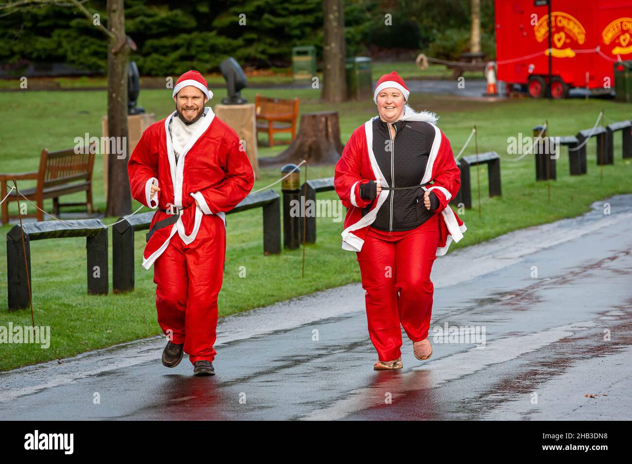 A couple dressed as Santas running in  a Santa Dash Stock Photo