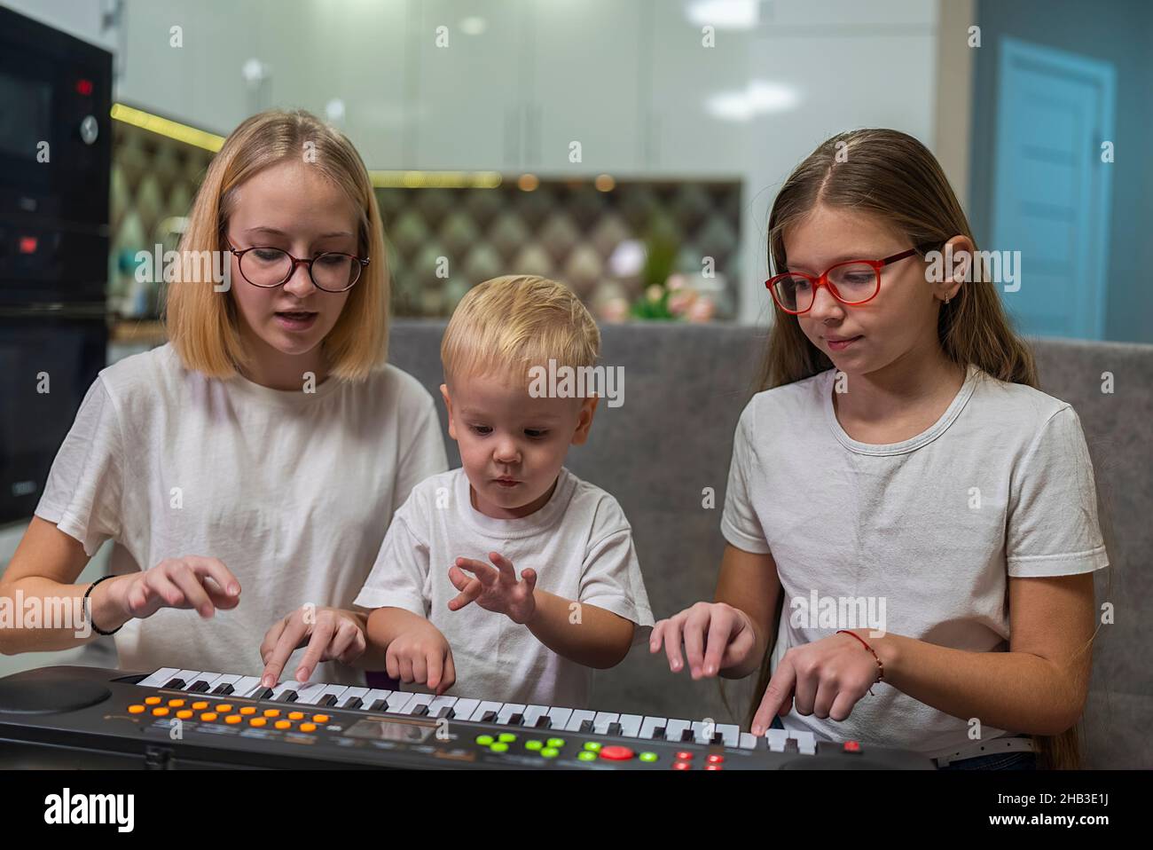 children learning to play the piano at home Stock Photo Alamy