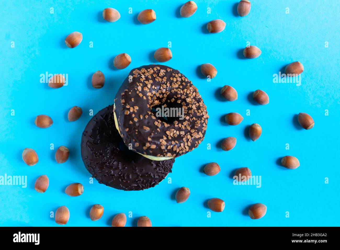Donut with hazelnuts on a blue background, close up Stock Photo