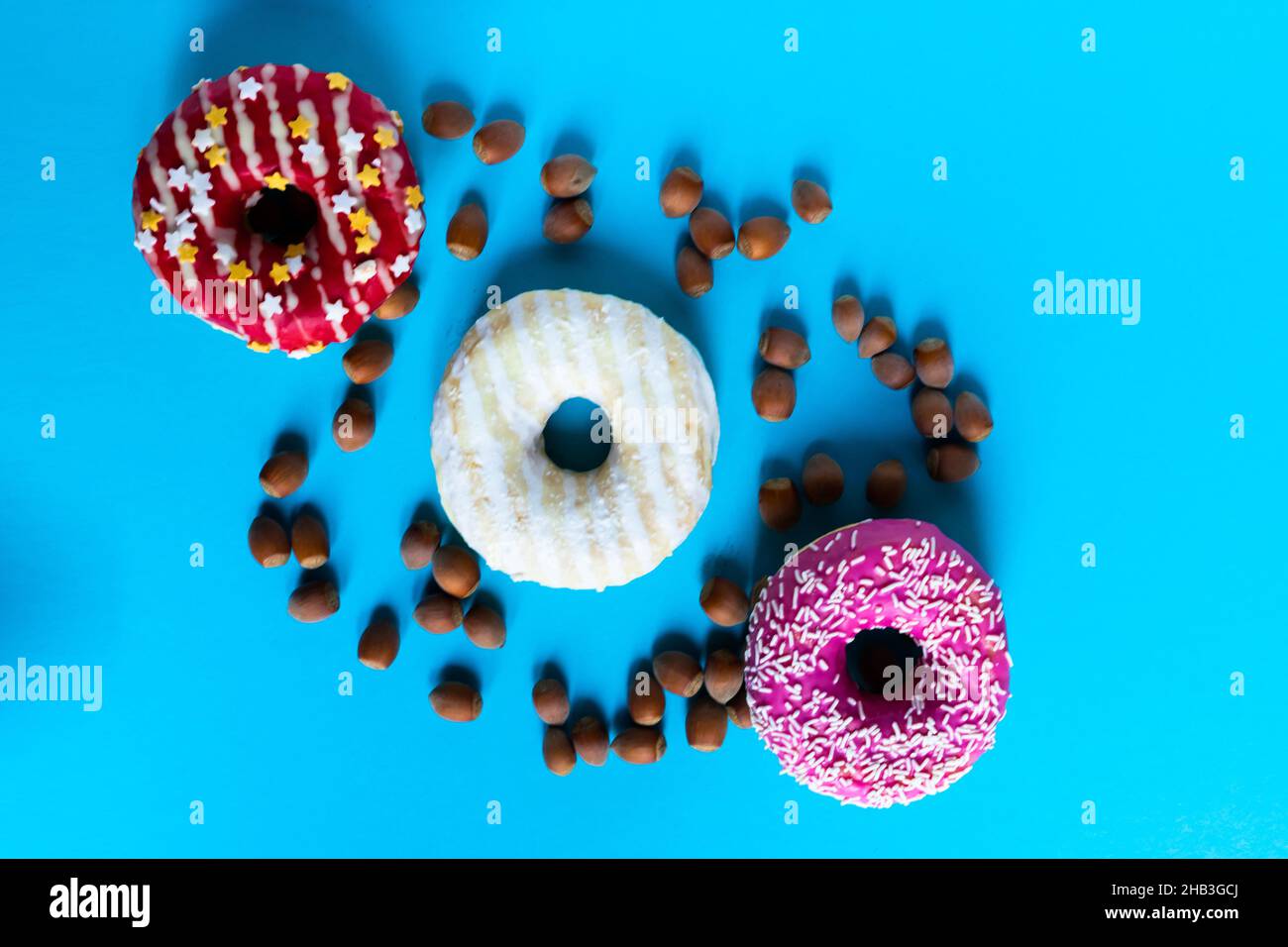 Donut with hazelnuts on a blue background, close up Stock Photo