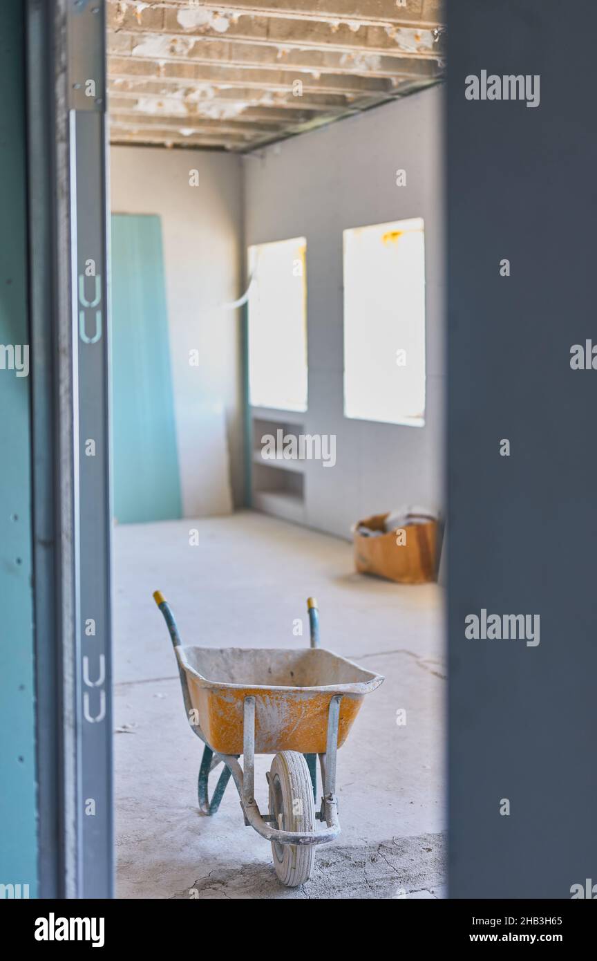 detail of a wheelbarrow in a room undergoing renovation in a building. Stock Photo