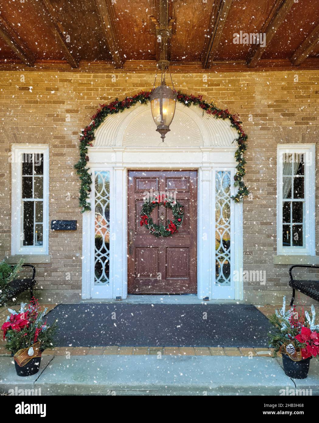 Wooden front door with Christmas wreath and garland decorations in snowflakes Stock Photo