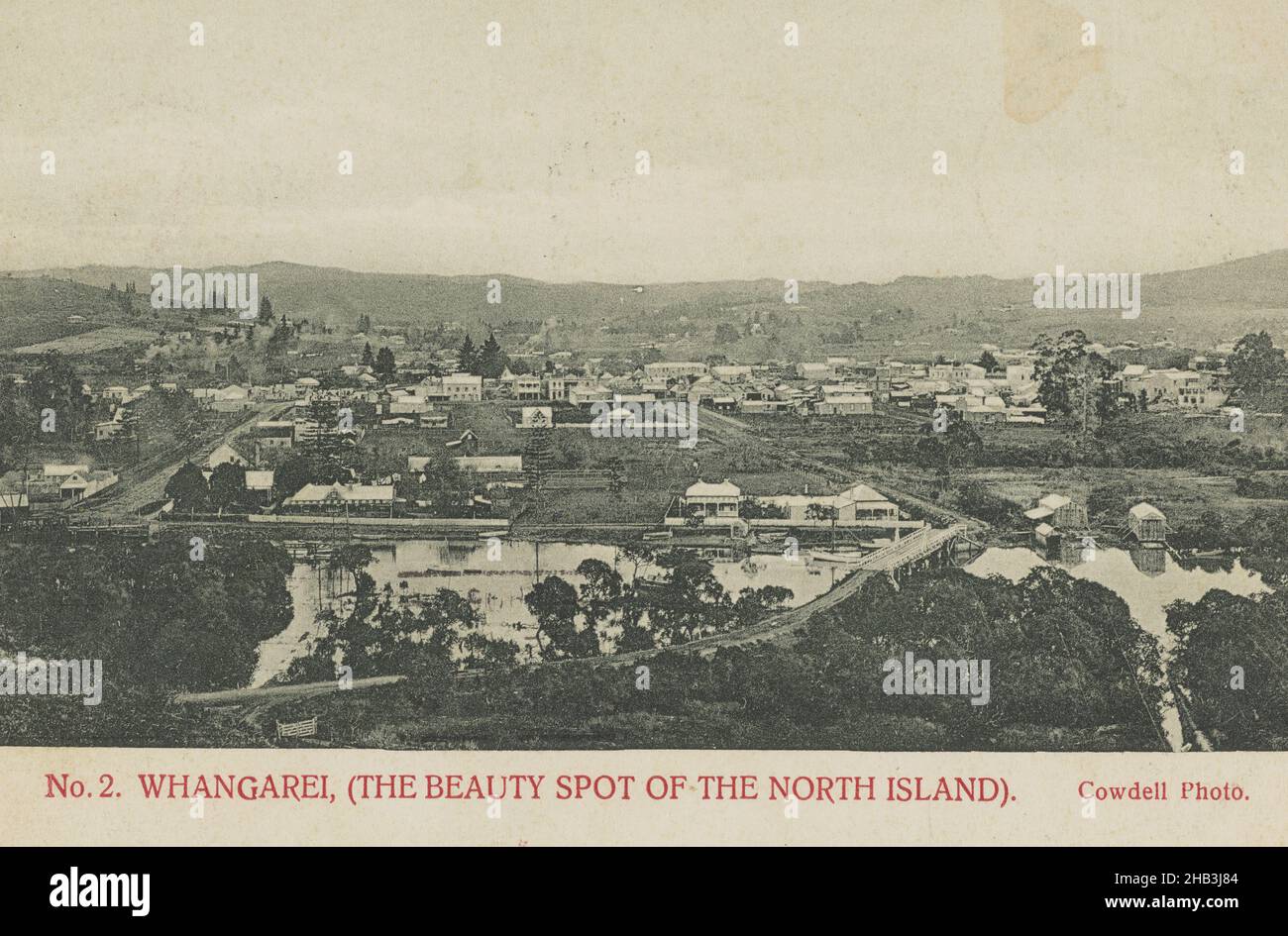Whangarei (The Beauty Spot of the North Island), Muir & Moodie studio, publisher, 1900-1903, Dunedin, collotype, View from hillside of township, road leading into town is in sight in the foreground. Also in sight in the foreground are river waters and the bridge that spans them Stock Photo