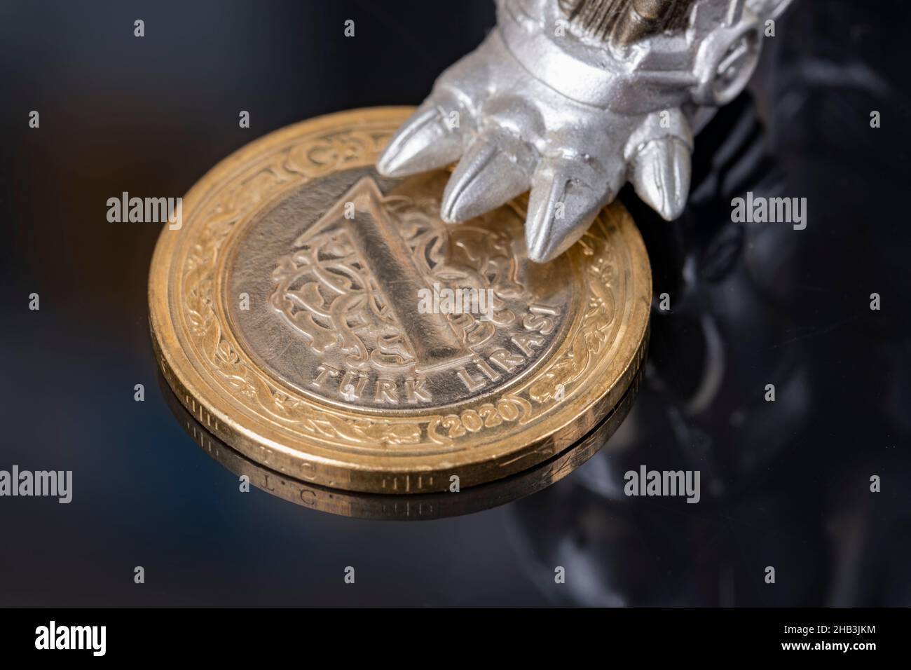 Monster feet standing on one Turkish Lira coin. TL losing value against inflation. Financial and economy dark background with copy space. Stock Photo
