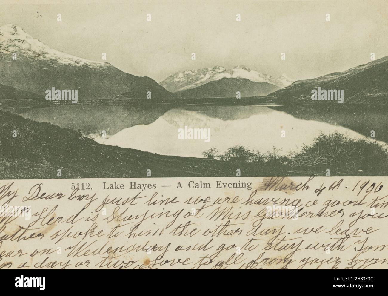 Lake Hayes, A Calm Evening, Muir & Moodie studio, publisher, 1900s, Dunedin, View looking over lake waters and towards snow capped mountains in the distance. Handwritten message is dated 4 March 1906. Card is addressed to: W. Wilkinson, 231 Tuam Street, Christchurch. The card was posted 5 March 1906 at Queenstown Stock Photo