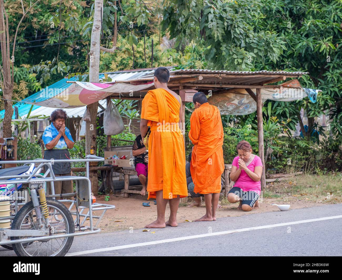 Buddhist monks receiving alms from Thai women early in the morning in Sam Roi Yot south of Hua Hin in Thailand. Stock Photo