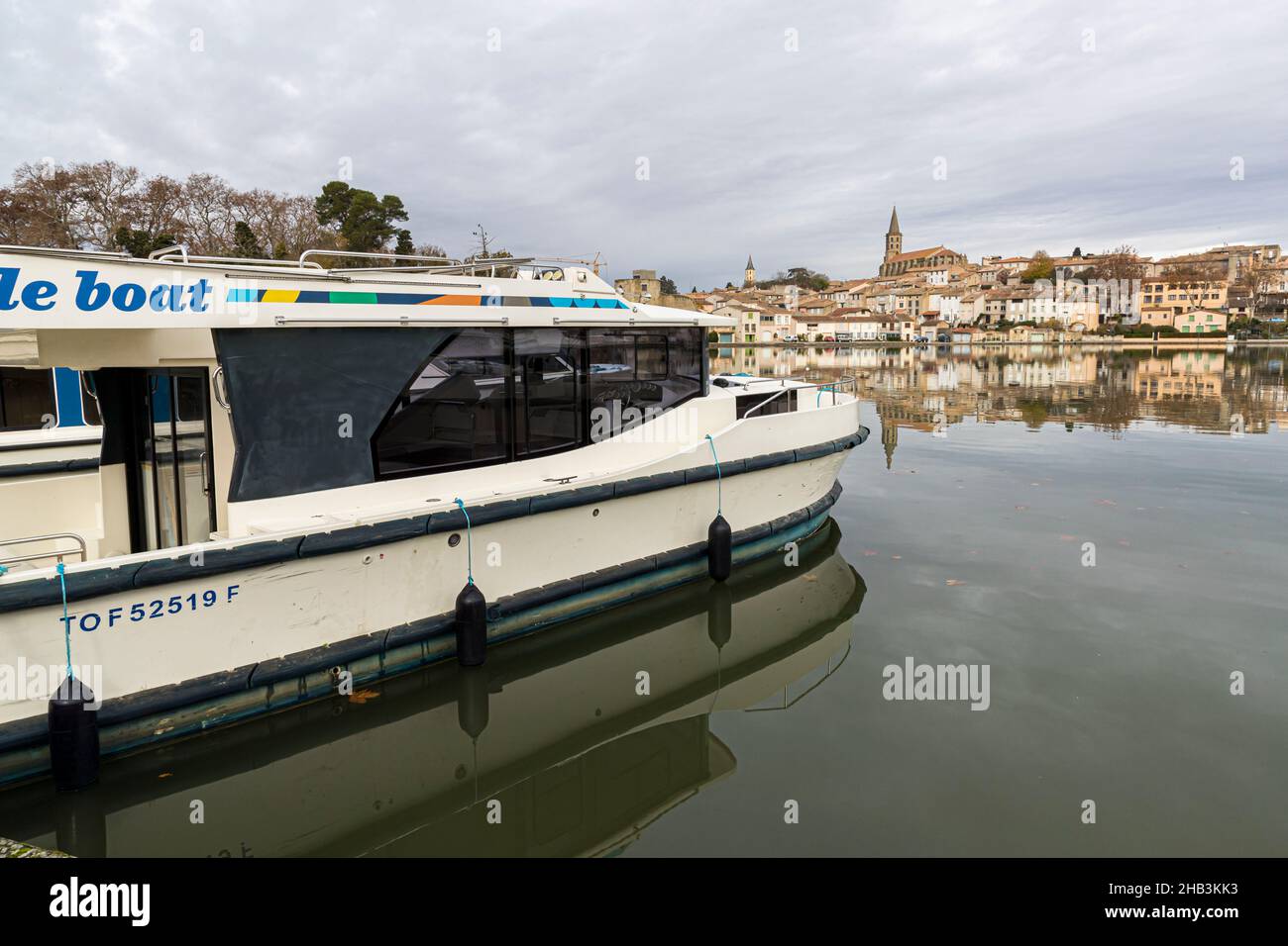 Castelnaudary (France) behind the basin of the Canal du Midi. In the foreground the houseboat fleet Le Boot, whose boats can be rented Stock Photo
