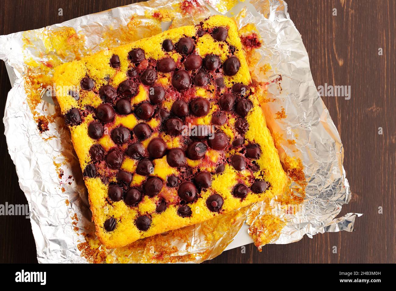 Homemade rustic quark pie with cherries baked in foil overhead view ...