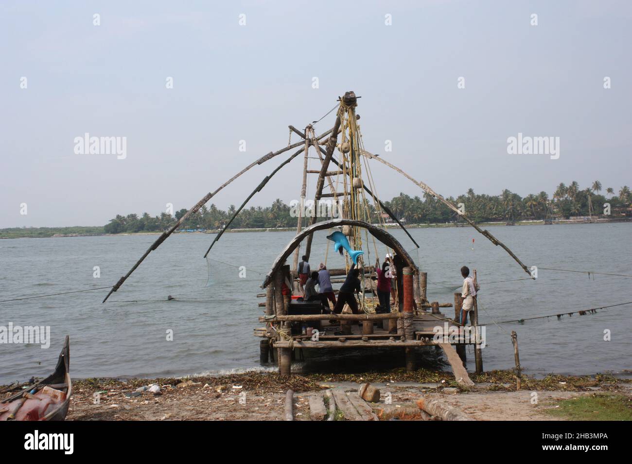 Fishermen with Cantilevered chinese fishing nets  in Kochi Kerala, India Stock Photo