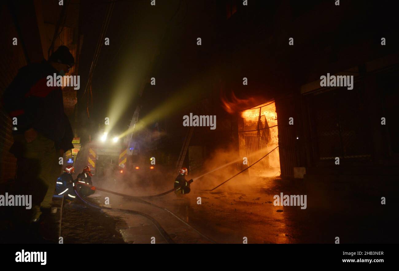 Lahore, Punjab, Pakistan. 15th Dec, 2021. Pakistani rescue 1122 Firefighters try to extinguish a fire that erupted in a Gas Calendar factory at Shalamar Garden area in Provincial Capital city Lahore, at least two persons killed and several injured shifted to near hospital. (Credit Image: © Rana Sajid Hussain/Pacific Press via ZUMA Press Wire) Stock Photo
