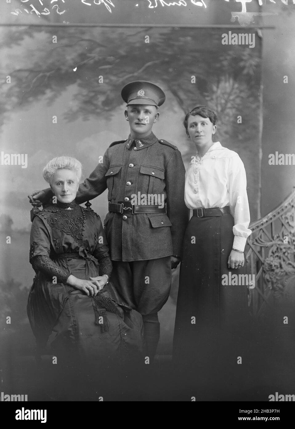 Portrait of an unidentified soldier and two unidentified women [inscribed Banks], Berry & Co, photography studio, 1916- 1917, Wellington, Portrait of a New Zealand soldier in the uniform of a Rifleman  in the Rifle Brigade, standing between two women, one seated and one standing. The older woman may be his mother, the younger may be a sister. Of the five New Zealand soldiers with the surname 'Banks' who served in the Rifle Brigade during WW1 Stock Photo